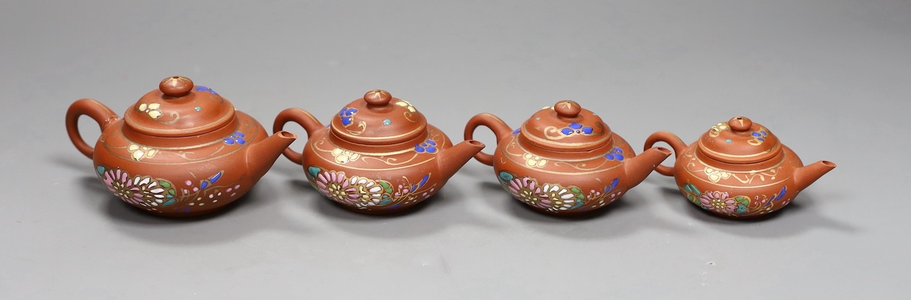 Four Chinese Yixing graduated enamelled miniature teapots, largest 5.5cms high